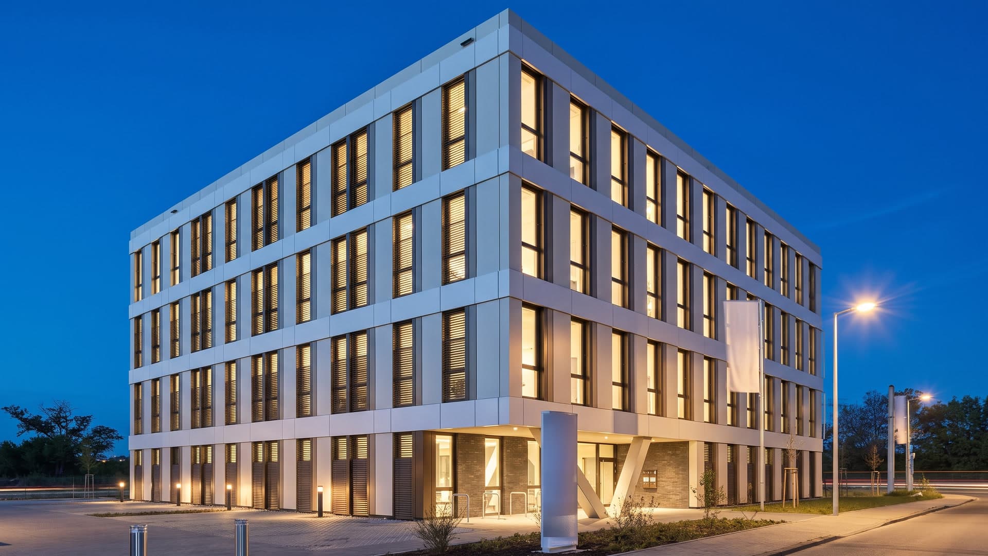 Standbild aus dem Film für ADLER: der Büroneubau ARTEM zur blauen Stunde, die Fenster leuchten warm (Visualisierung)